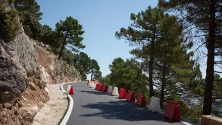 Carretera con barreras blanca y rojas en la Sierra de Cádiz.