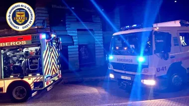 Dos camiones de bomberos junto al edificio del incendio.