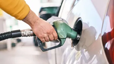 Persona poniendo gasolina 95 low-cost en su coche.