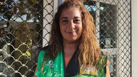 Chica del ONCE con su chalequillo característico en verde y letras amarillas.