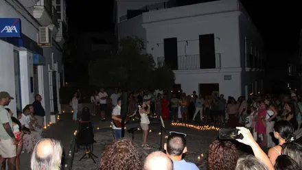 Chica cantando en la calle en una actuación urbana en la Noche de las Velas Fenicias de Chiclana.