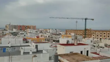 Cielos nublados sobre el Campo del Sur de Cádiz, con el edificio de Valcarcel y la grúa de sus obras en primer término.
