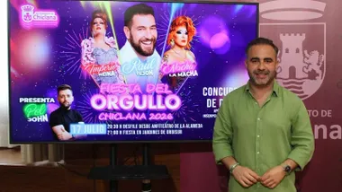 El delegado de Chiclana, Fede Díaz, presentando el evento del Orgullo junto a una pantalla de video.