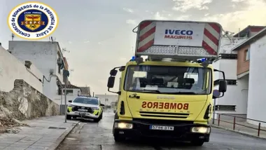 Camión y coche de bomberos, en amarillo y rojo, en el lugar del incendio.
