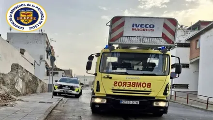 Camión y coche de bomberos, en amarillo y rojo, en el lugar del incendio.