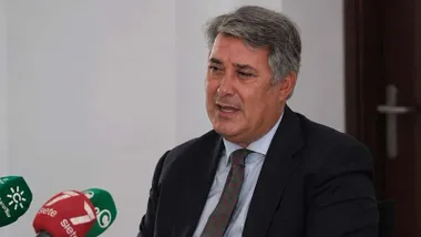 Imagen de Ignacio Romaní en una rueda de prensa, se ven los micrófonos, en rojo y verde, de los medios.