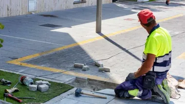 Trabajador poniendo el acerado en Rota.