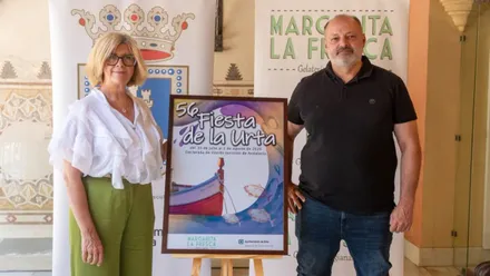 Delegada y organizador junto al cartel de la 56 Fiesta de la Urta.