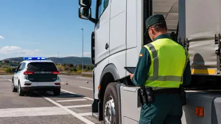 Control de carreteras en el que un agente de la Guardia Civil revisa un tacógrafo.