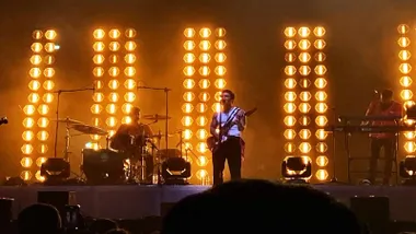 Álvaro de Luna cantando en el escenario, tras él destacan los focos de color anaranjado-amarillento.