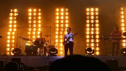 Álvaro de Luna cantando en el escenario, tras él destacan los focos de color anaranjado-amarillento.