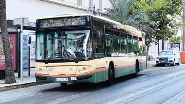 Un autobús urbano de la Línea 2 de Cádiz circula por una calle de la ciudad con el número 2 y los destinos Plaza de España, Puntales y Loreto visibles en el panel frontal.