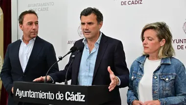 Bruno García interviene ante dos micrófonos en una rueda de prensa del Ayuntamiento de Cádiz, acompañado por José Manuel Cossi, a su izquierda, y Maite González, a su derecha.