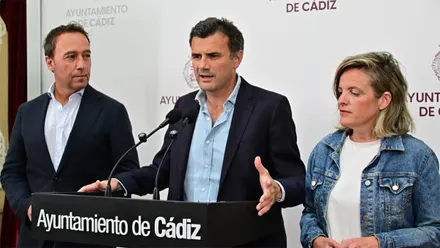 Bruno García interviene ante dos micrófonos en una rueda de prensa del Ayuntamiento de Cádiz, acompañado por José Manuel Cossi, a su izquierda, y Maite González, a su derecha.