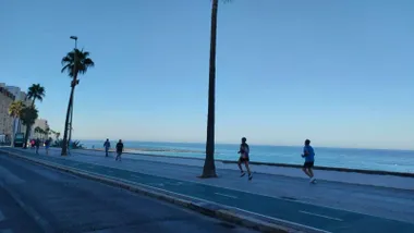 Paseo de Cádiz con el cielo despejado y personas caminando o haciendo footing.