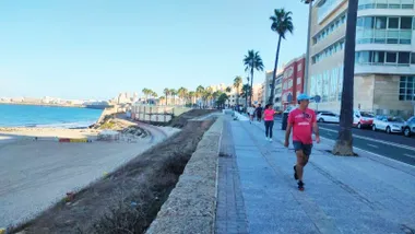 Varias personas corren por el Paseo Marítmo de Cádiz a la altura de la playa de Santa María del Mar