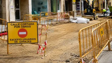 Calle cortada por obras en Cádiz, hay vallas de color amarillo y señalización.