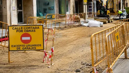 Calle cortada por obras en Cádiz, hay vallas de color amarillo y señalización.