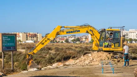 Excavadora de color amarillo trabajando en un camino.