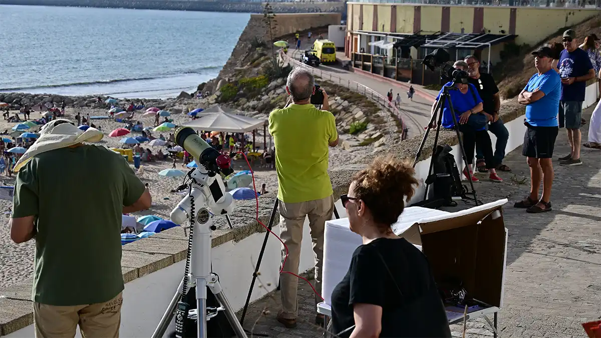 Varios telescopios y equipos de observación preparados junto a una playa de Cádiz durante el eclipse solar de 2026.