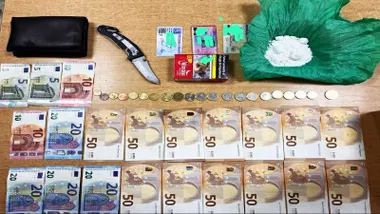 Mesa en la que hay dinero, de diferente valor, droga y una navaja.