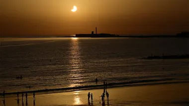 Eclipse parcial de Sol sobre el Castillo de San Sebastián visto desde la playa de Santa María del Mar de Cádiz durante el 12 de agosto de 2026.