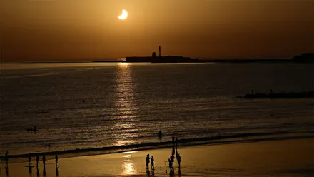 Eclipse parcial de Sol sobre el Castillo de San Sebastián visto desde la playa de Santa María del Mar de Cádiz durante el 12 de agosto de 2026.