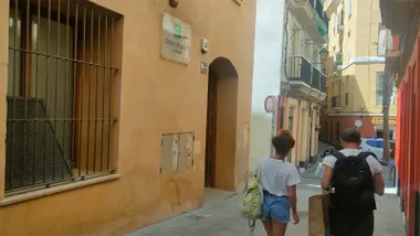 Fachada y entrada del Centro de Salud La Merced, en el barrio de Santa María de Cádiz, mientras varias personas caminan por delante del edificio.