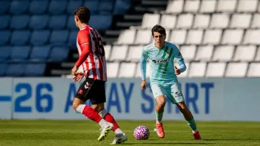 El jugador uruguayo Gonzalo Petit recibiendo un balón, vista de celeste con una bandera diagonal de Andalucía en la camiseta.