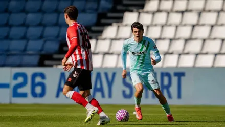 El jugador uruguayo Gonzalo Petit recibiendo un balón, vista de celeste con una bandera diagonal de Andalucía en la camiseta.