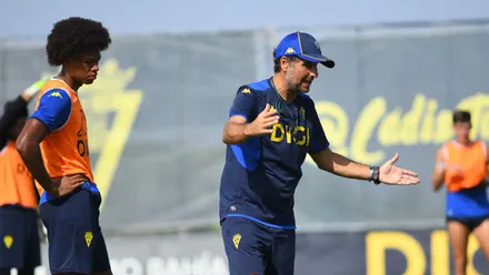 El entrenador del Cádiz CF, Imanol Idiakez, da instrucciones durante una sesión de entrenamiento en la Ciudad Deportiva. A su lado, un futbolista escucha las indicaciones mientras el equipo prepara la nueva temporada.