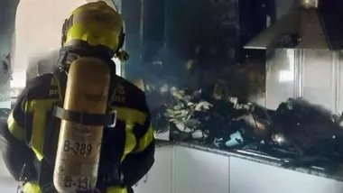 Bombero en el interior de una cocina quemada.