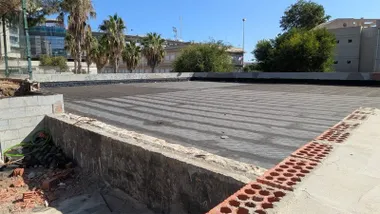 Vista de la cubierta de los locales de Telegrafía Sin Hilos, recubierta con tela asfáltica negra y rodeada de muros y restos de materiales de obra.
