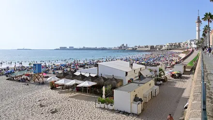 Vista de la playa de Santa María del Mar, en Cádiz, llena de bañistas y sombrillas durante un día de verano.