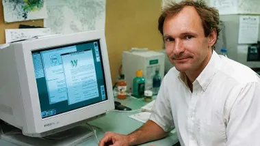 Tim Berners-Lee junto a un ordenador y la primera web de la Historia.