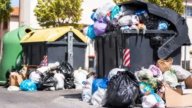 Diferentes contenedores de basura repletos de bolsas.