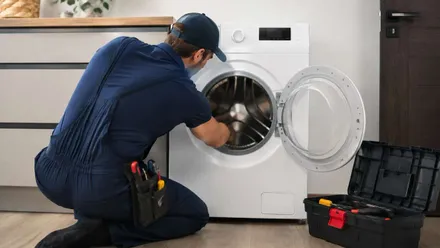 Técnico reparando una lavadora.