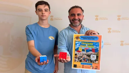 Fede Díaz y una chico con el cartel del Chiclana Open 2026 y el Cubo Mágico de Rubik.