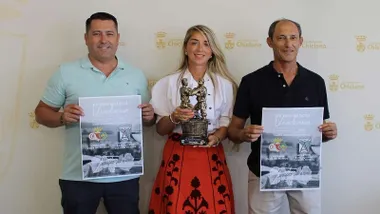Tres responsables de la organización del XV Trofeo de la Vendimia de Chiclana posando con el cartel del mismo.