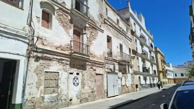 Viviendas en estado de abandono, con paredes desgastadas en una calle de Cádiz.