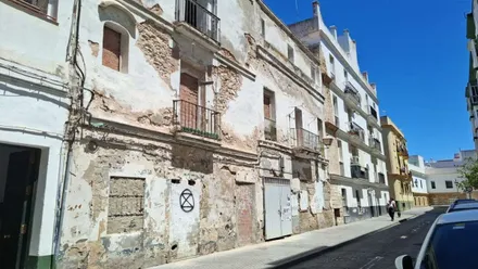 Viviendas en estado de abandono, con paredes desgastadas en una calle de Cádiz.
