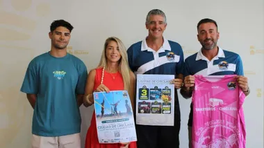 Autoridades y organizadores posan con el cartel del evento deportivo en La Barrosa.