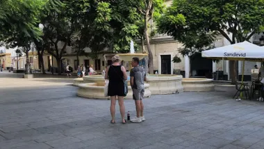 Dos turistas observan un mapa de Cádiz en la plaza del Mentidero de la capital gaditana.