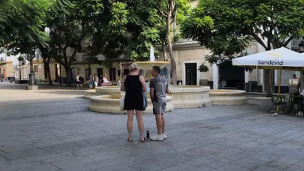 Dos turistas observan un mapa de Cádiz en la plaza del Mentidero de la capital gaditana.