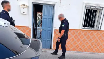 Dos agentes de la Policía Local de Algodonales junto a la puerta de entrada de la casa que se pretendía ocupar.