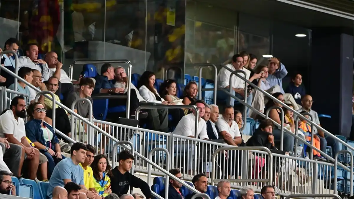 Vista del palco del Nuevo Mirandilla durante el Cádiz-Girona, con el alcalde de Cádiz consultando su teléfono móvil y dos concejales sentados junto a él en la segunda fila, detrás de otros asistentes