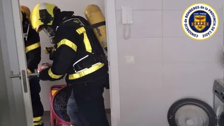 Un bombero con equipo de respiración en una cocina con azulejos blancos.