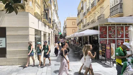 Calle Columela, en el centro de Cádiz en un día soleado, con numerosos peatones caminando entre comercios y terrazas de hostelería.