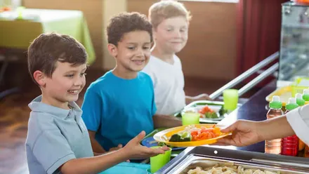 Niños en el momento de coger su comida.