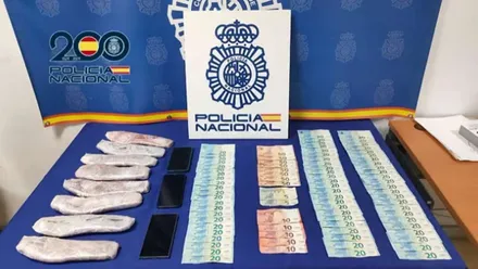 Mesa de la Policía Nacional con dinero y droga incautadas en el vehículo.